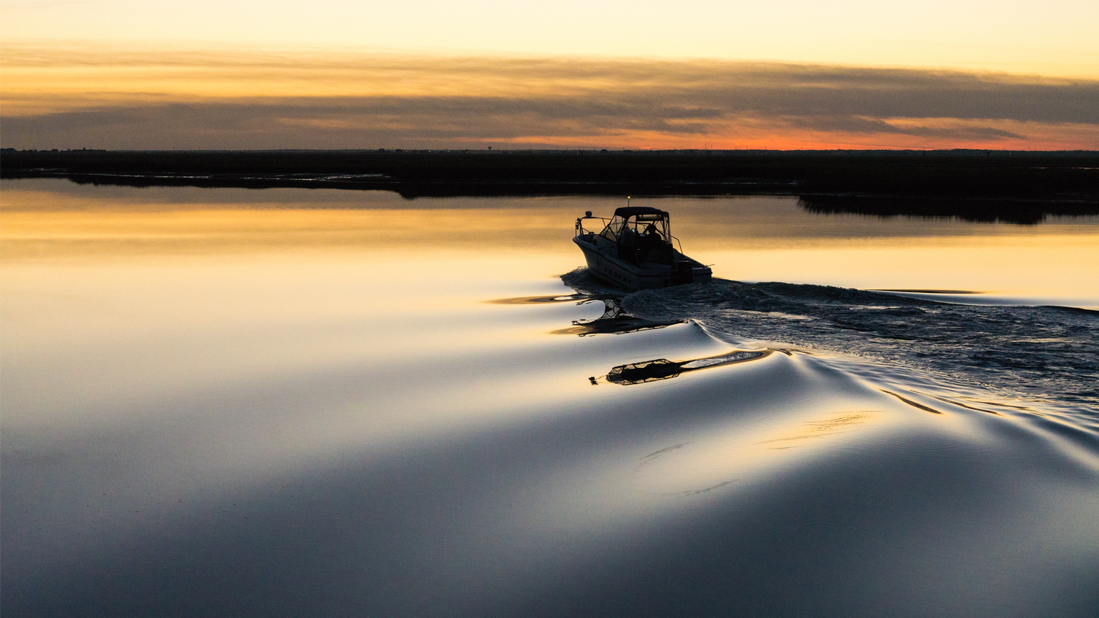 Boat on a calm Ontario lake at sunset