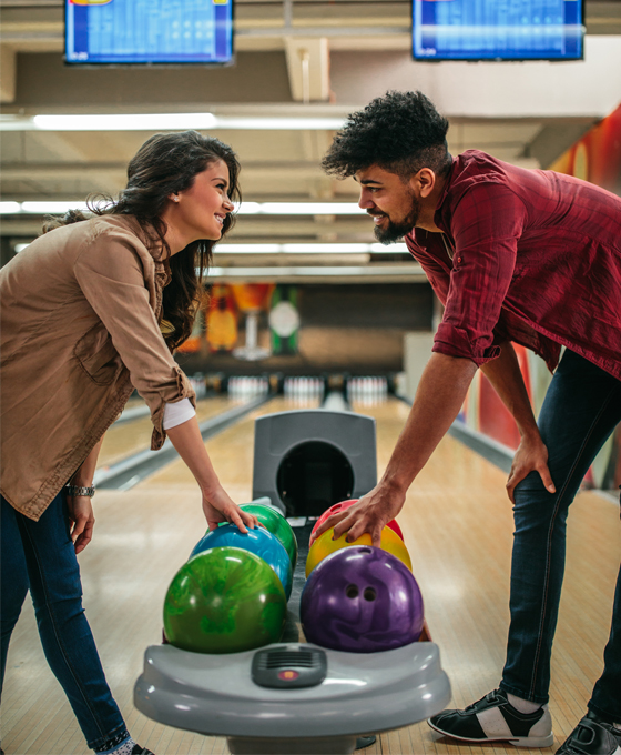 Couple smiling at each other while bowling